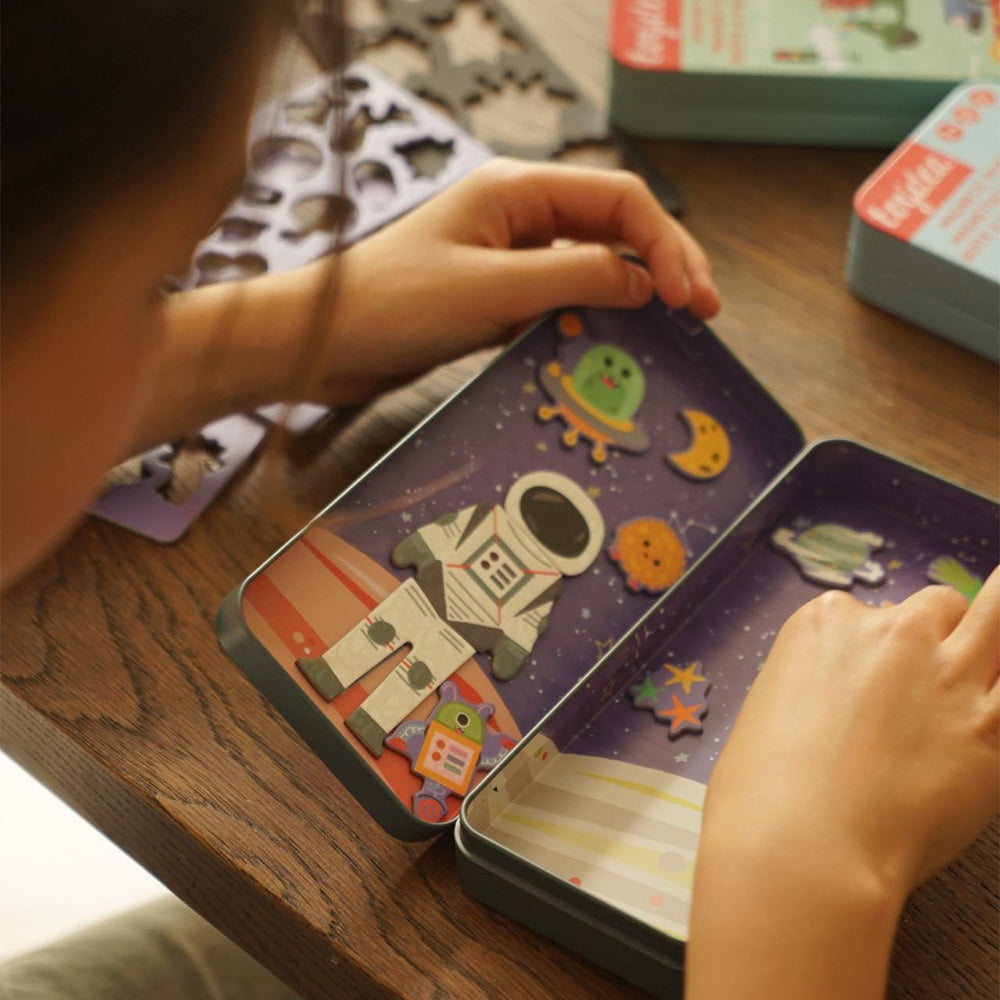 Ein Kind platziert einen magnetischen Astronauten in der Toydea 'Weltraum' Spielbox.