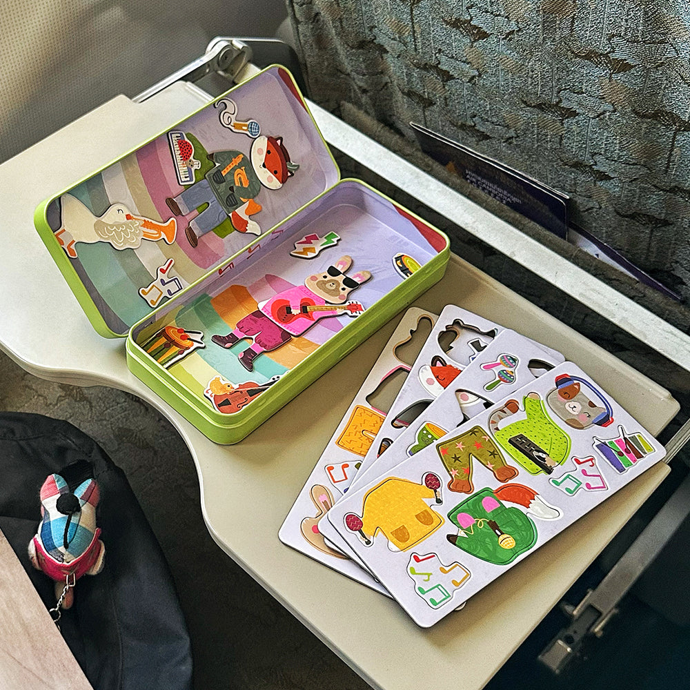 Ein Kind beschäftigt sich während eines Fluges mit der Toydea 'Musik' Magnetspiel-Box auf dem Klapptisch.