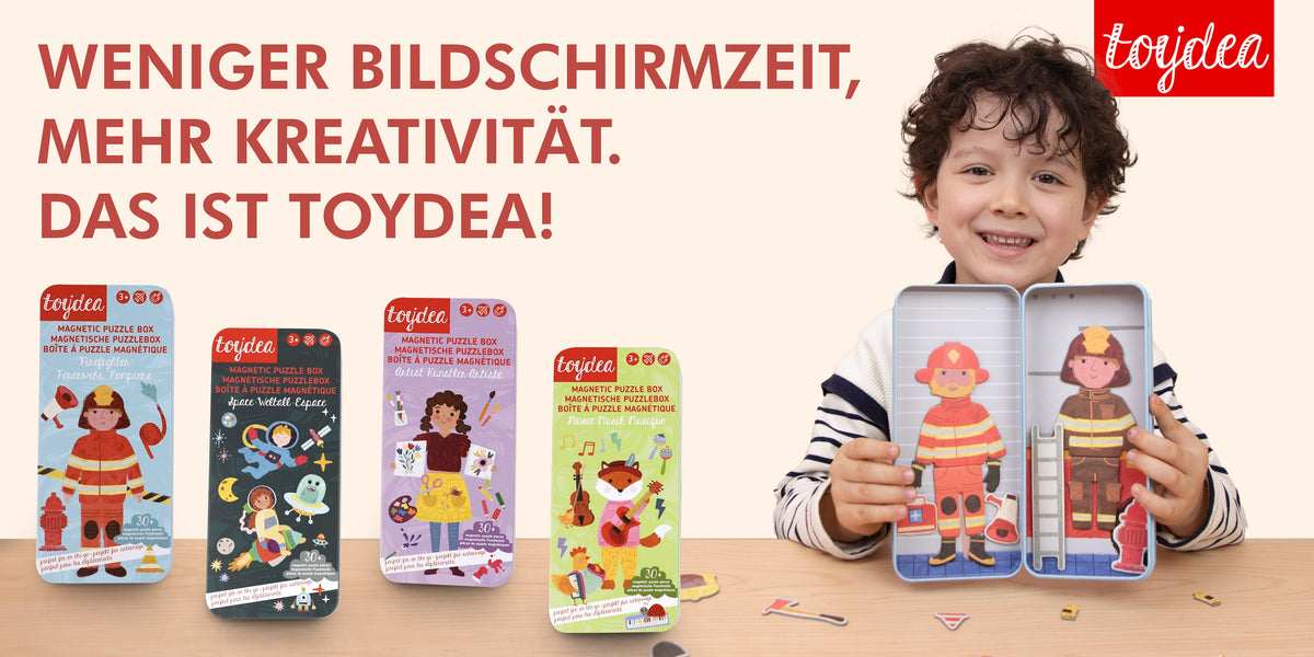 Ein glücklicher Junge spielt mit der Toydea Magnetspiel-Box 'Feuerwehrmann'.